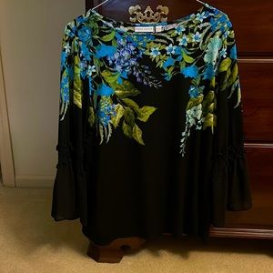 Black top with floral design around the neck and upper bodice.
